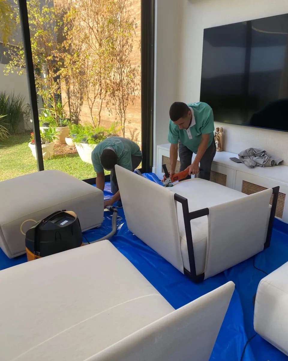 Equipe CleanSOS JF higienizando poltronas e puffs em uma casa de Juiz de Fora